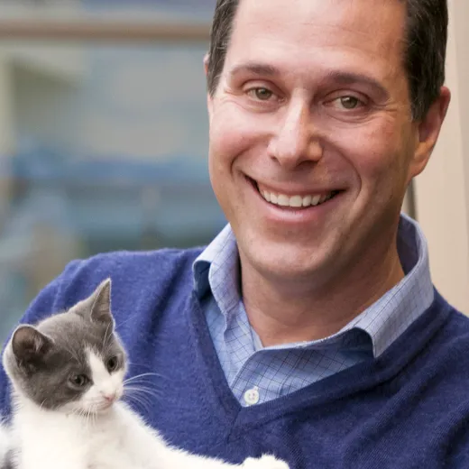 CEO of San Diego Humane Society holding a kitten.