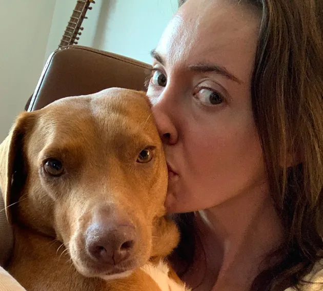 Kali the dog getting a kiss from his mom.