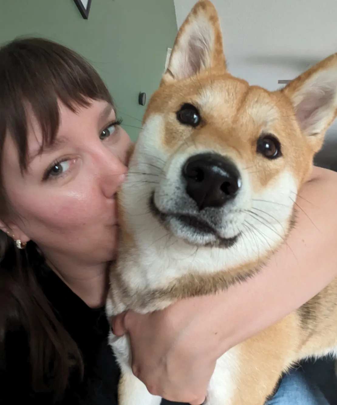 Aki the dog getting a kiss from mom.