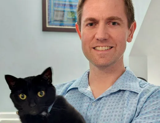 A Fetch employee holding their cat.