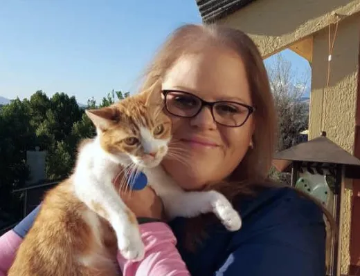 A Fetch employee holding their cat.