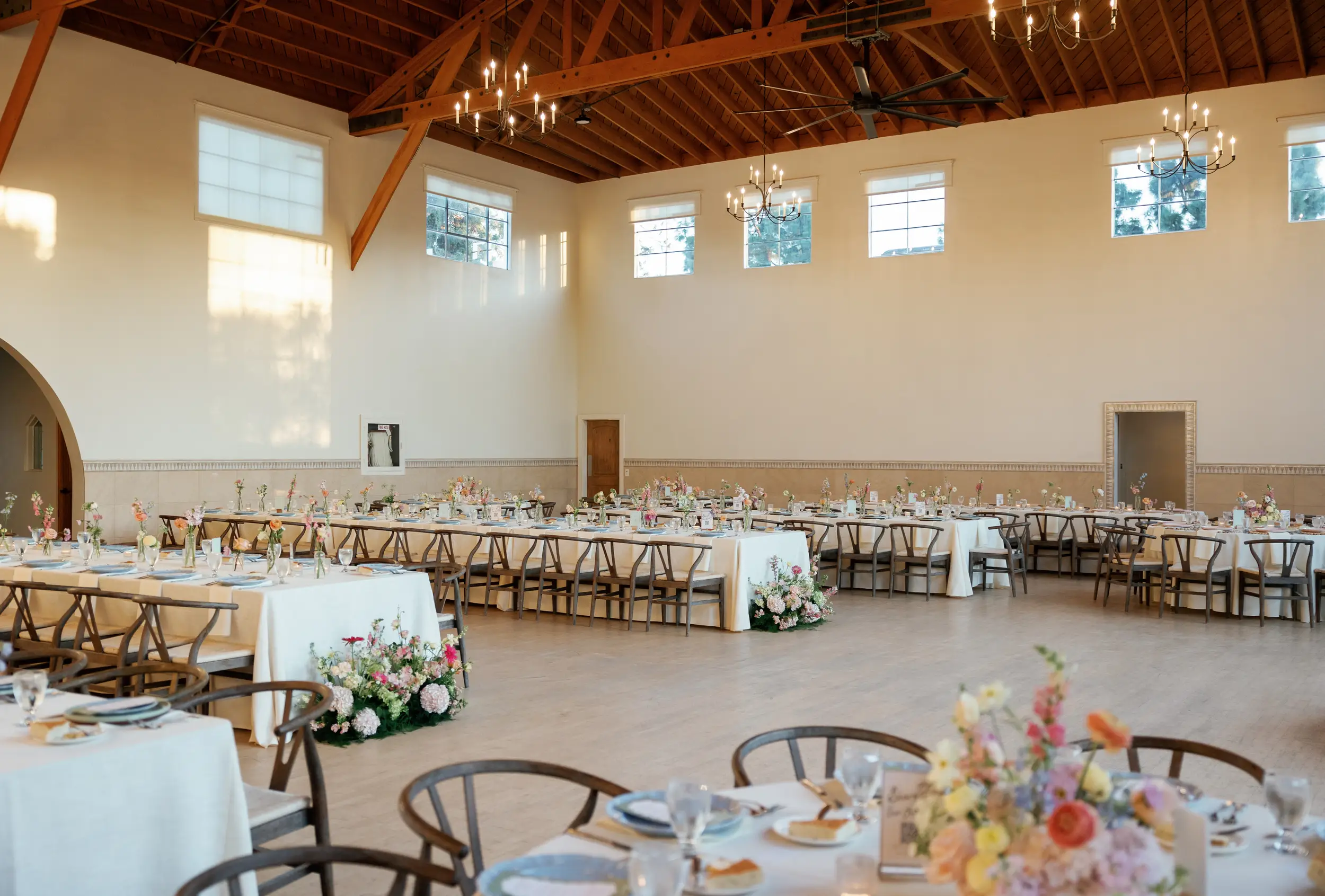 Reception tables set inside Grand Gimeno with colorful details and florals.