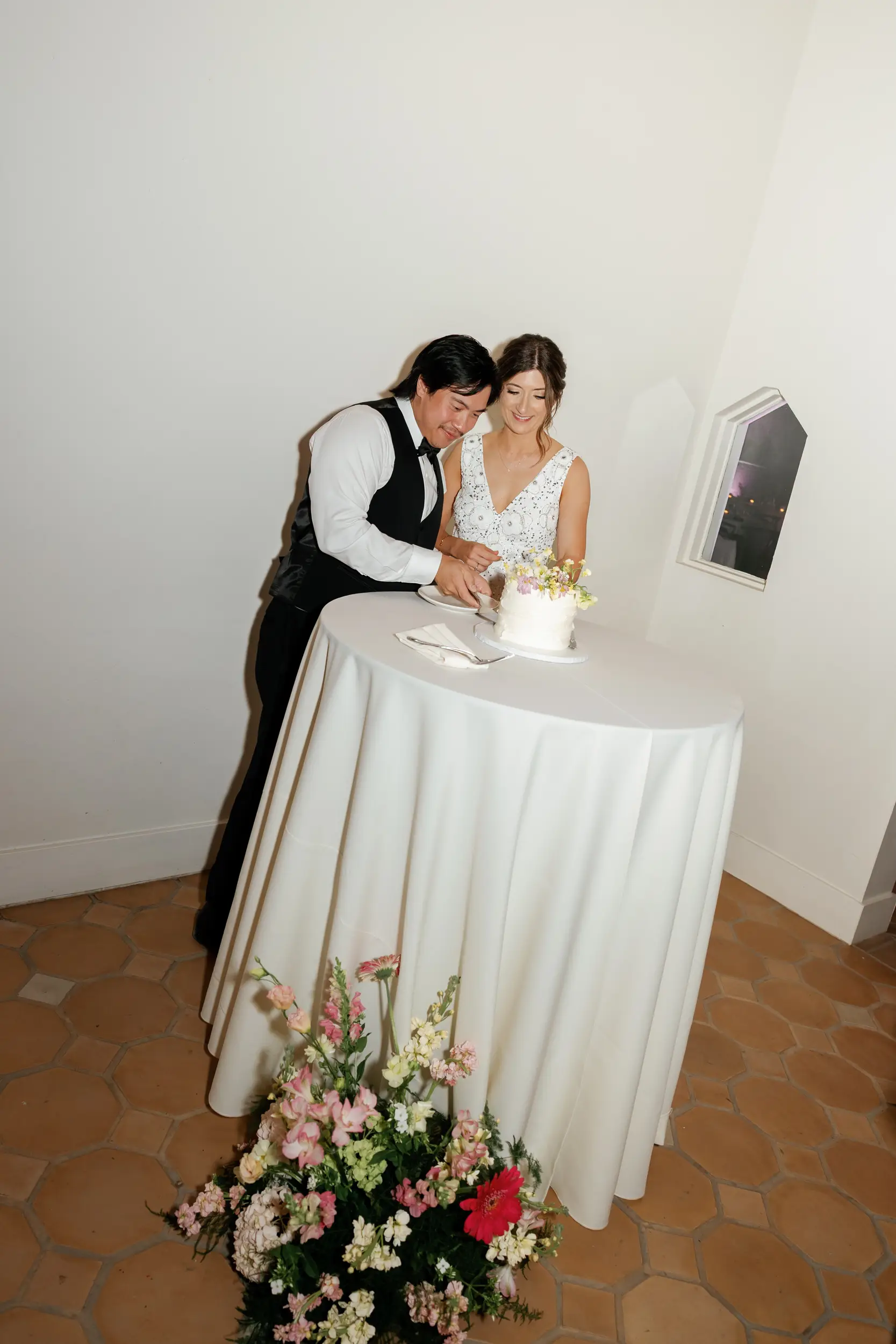 Bride and groom cutting wedding cake.