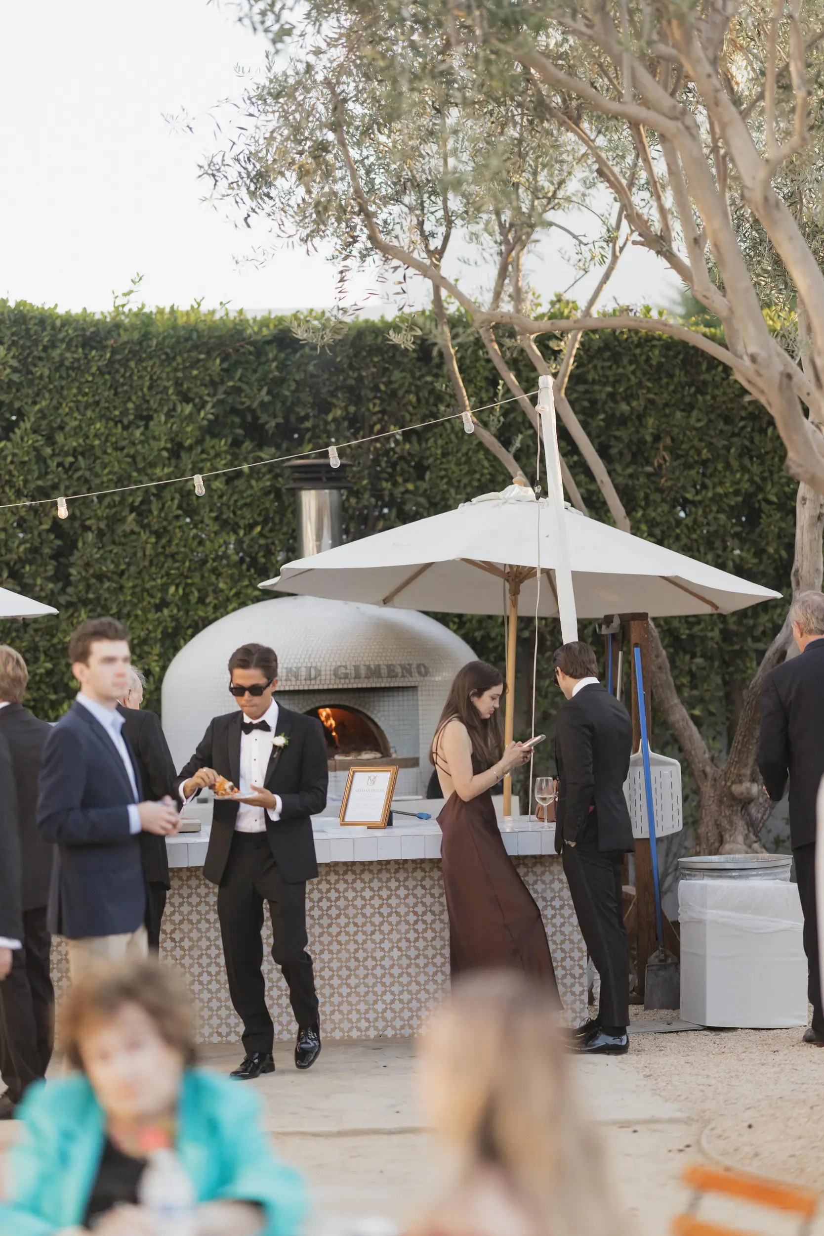 Guests grab fresh wood-fired pizza from the Grand Gimeno pizza oven station.