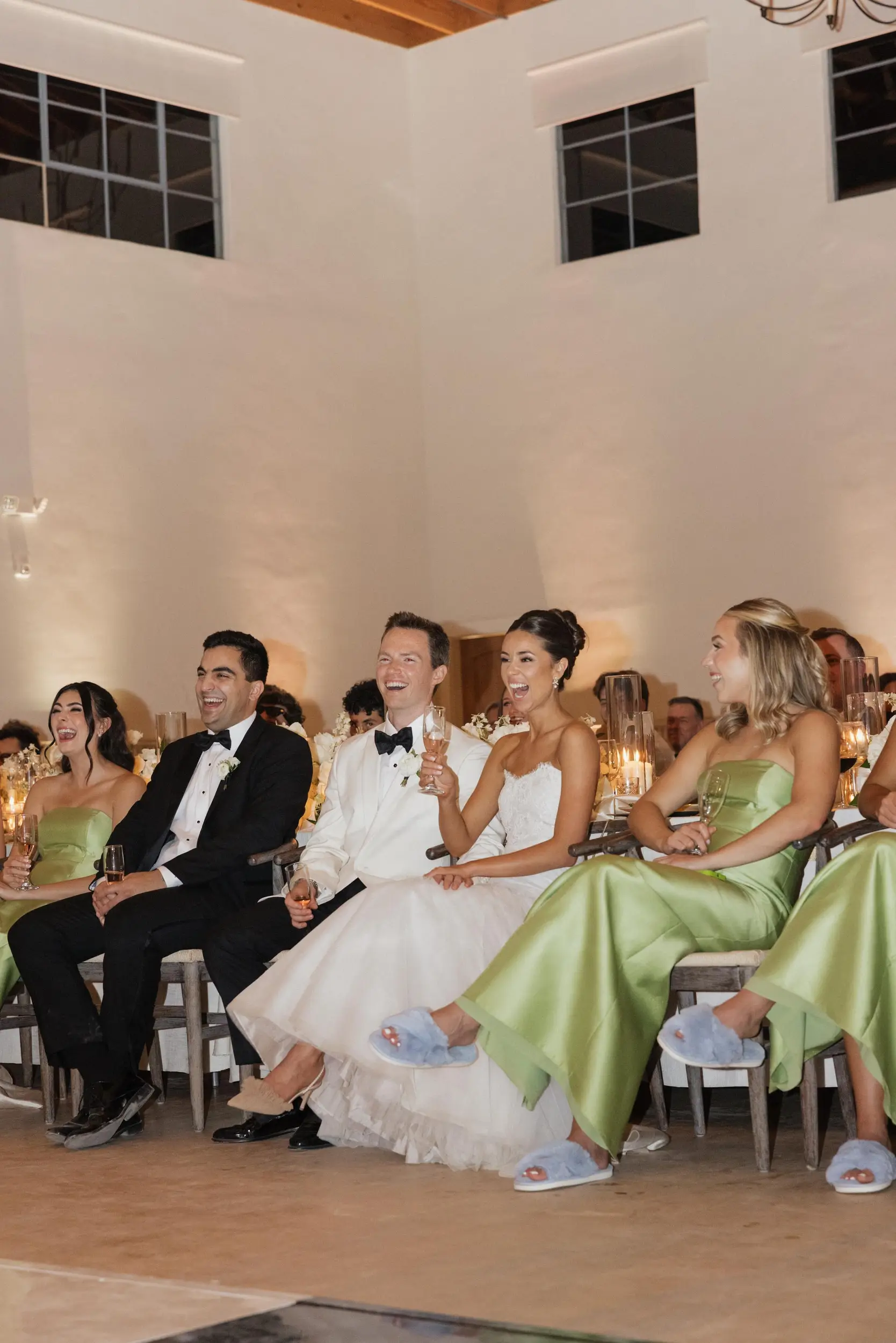 Bride and groom smile while a toast is shared.
