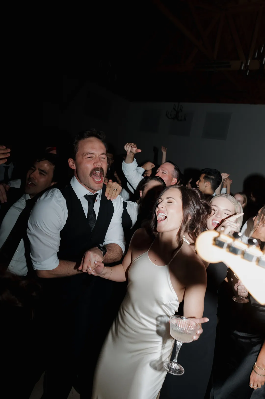 Bride and groom sing to live band out on the dance floor.