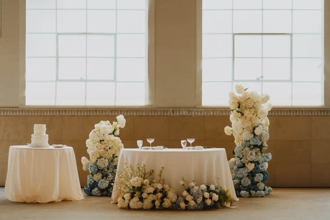 Reception sweetheart table framed by white floral columns