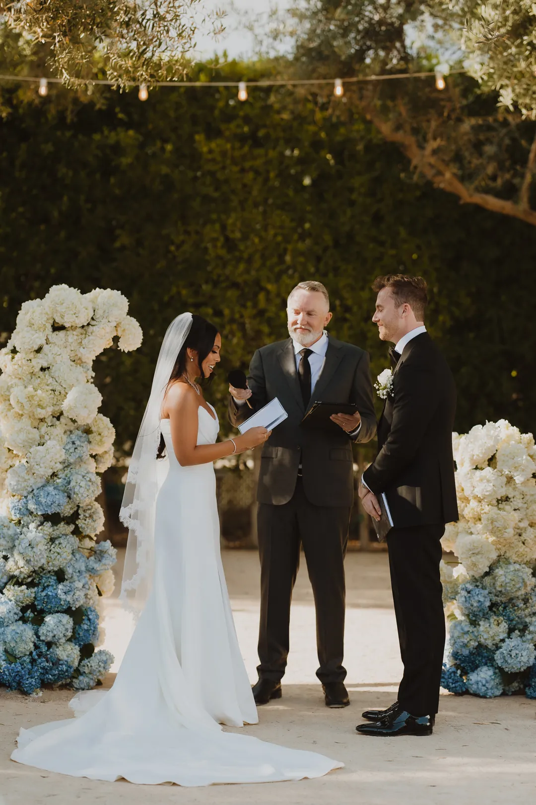 Bride and groom exchanging vows beside an officiant