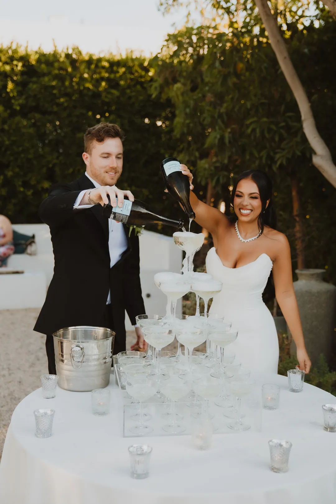 Bride and groom pouring champagne into stacked glasses