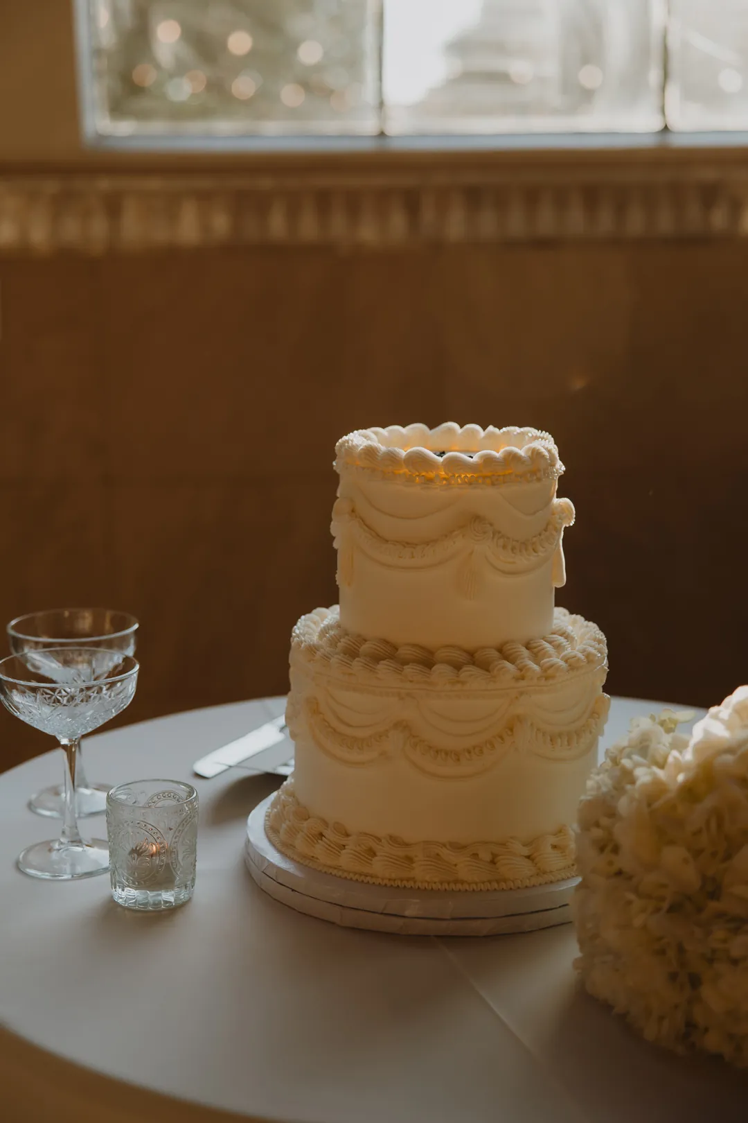 White tiered wedding cake with piped decoration