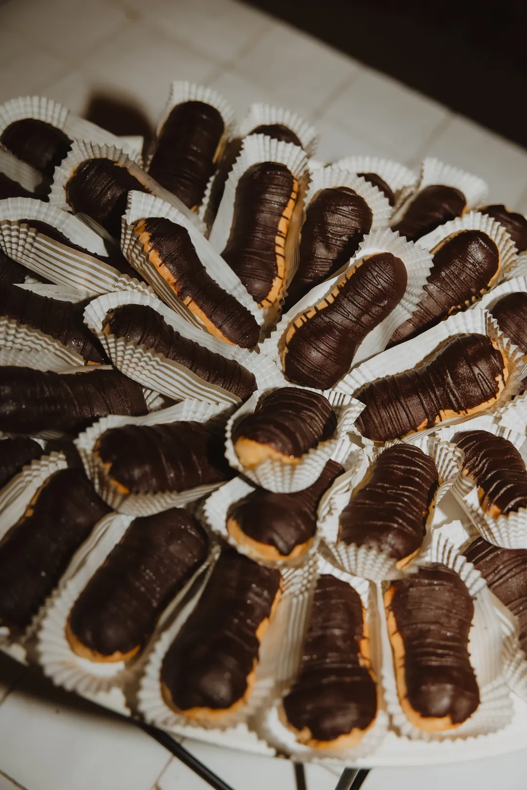 Chocolate-topped pastries on a white serving platter