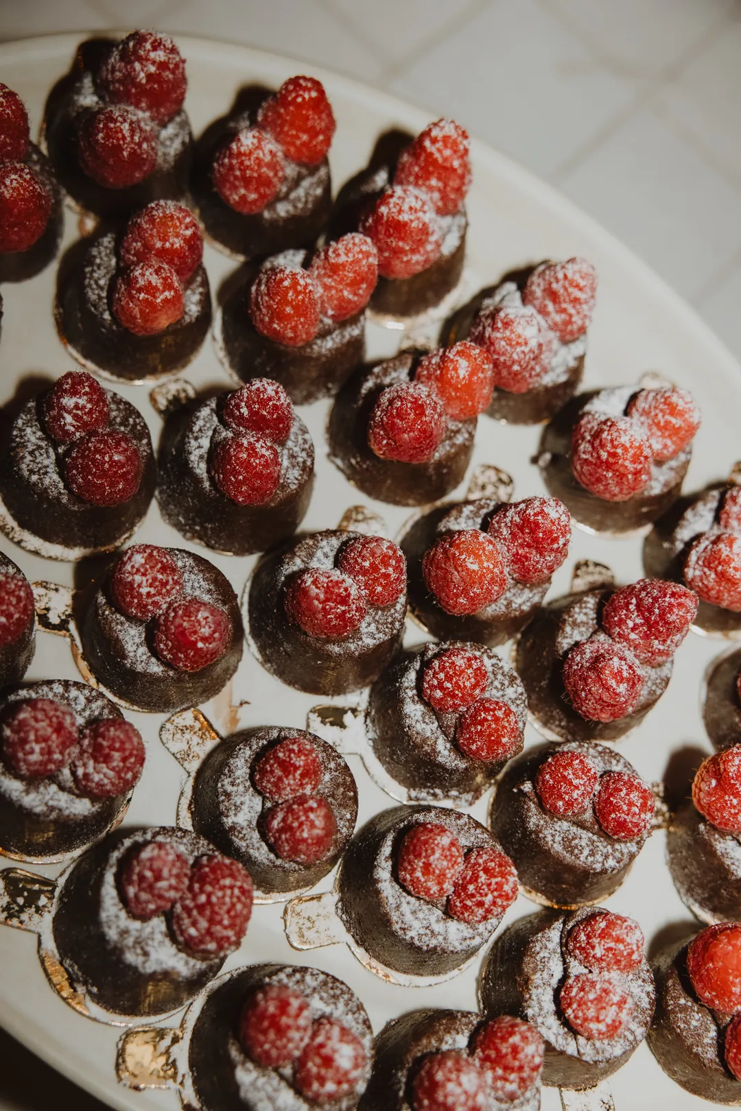 Chocolate desserts topped with raspberries and powdered sugar