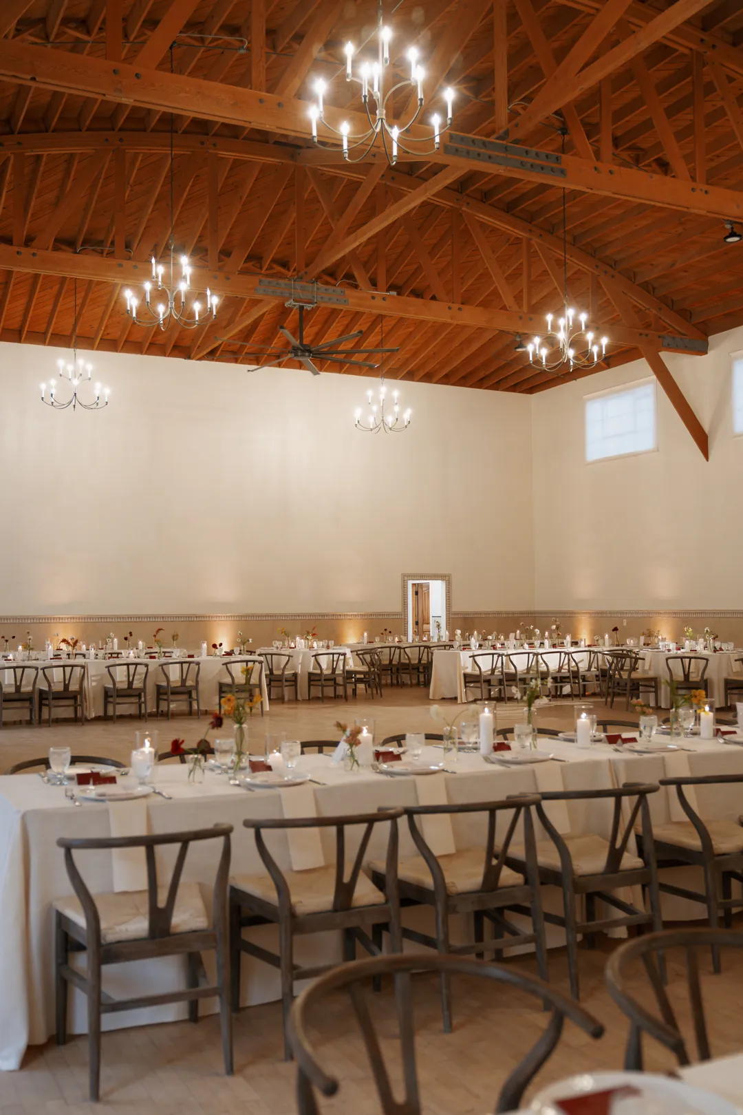 Reception tables beneath tall walls and wood rafters