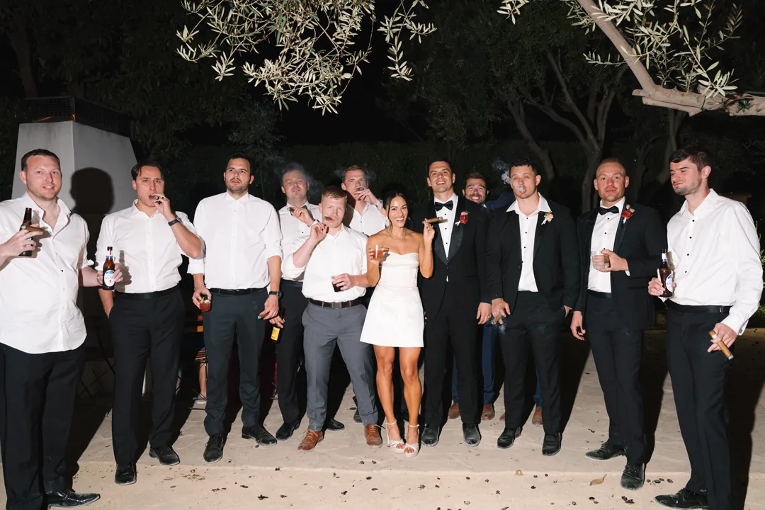 Bride and groom posing with friends outdoors after dark