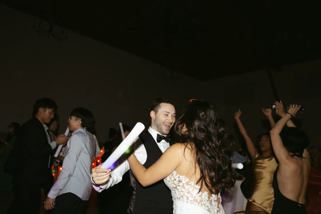 Bride and guests dancing with glowing light sticks