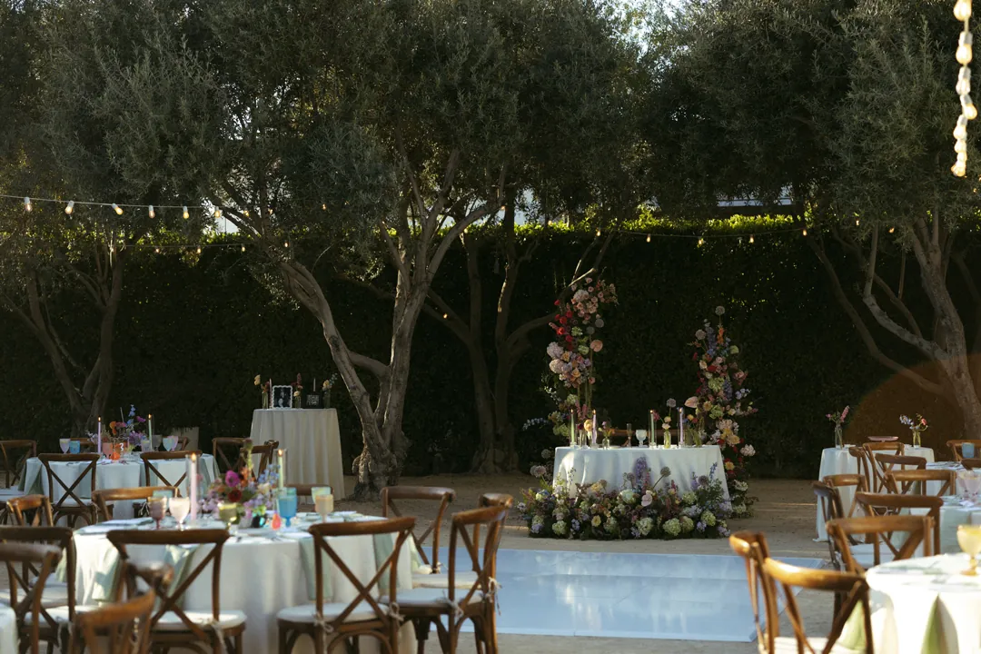 Outdoor sweetheart table beneath courtyard trees