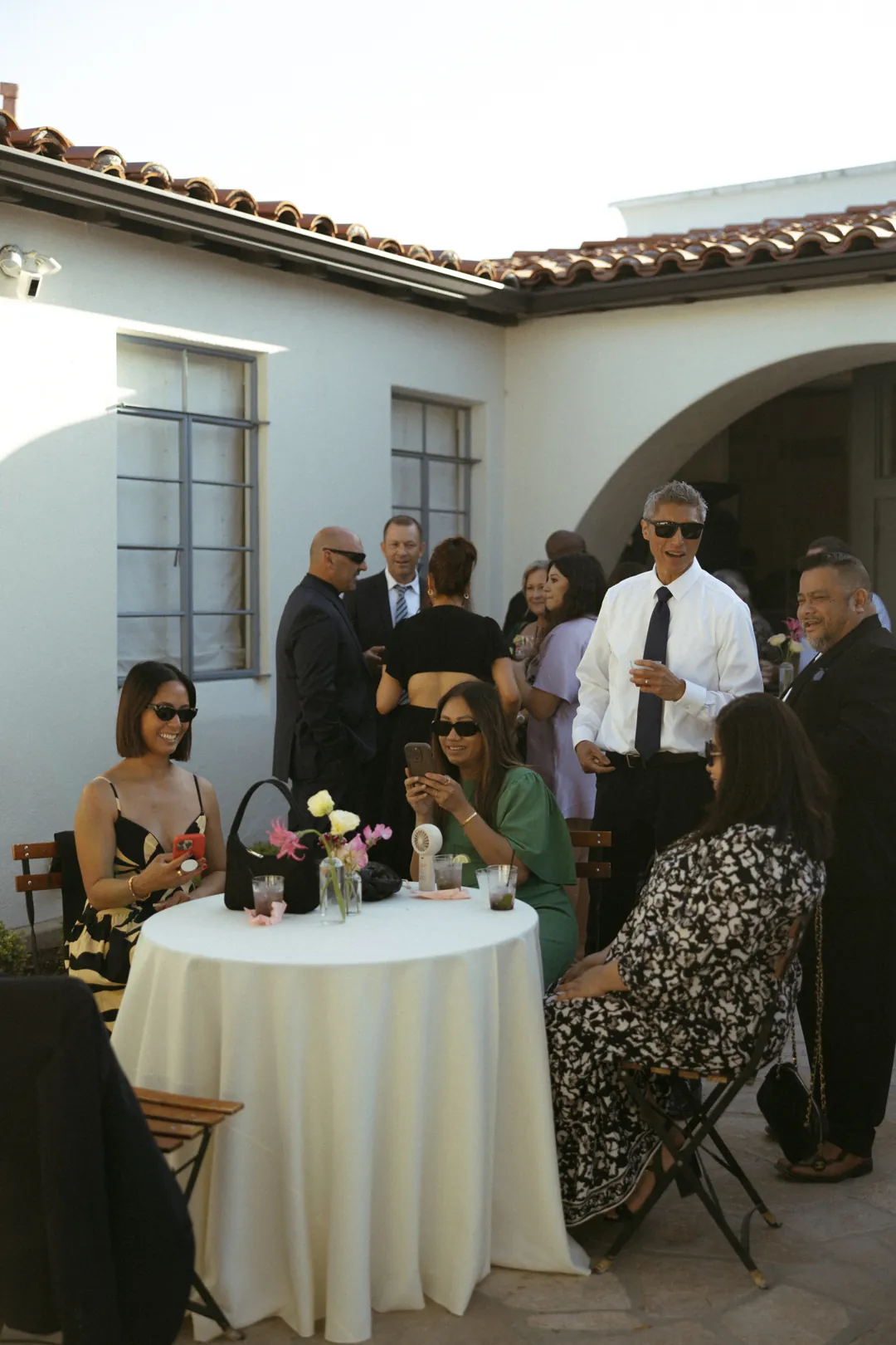 Guests chatting around a courtyard cocktail table