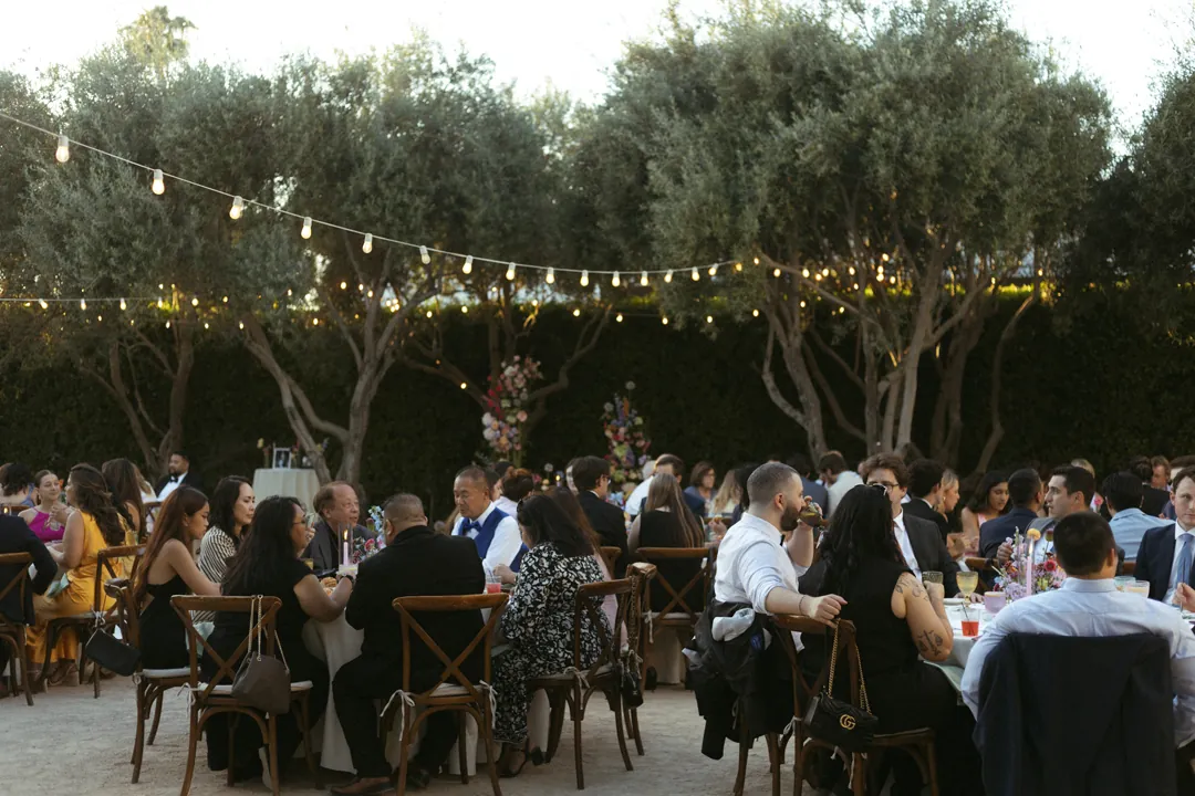 Guests dining beneath courtyard string lights