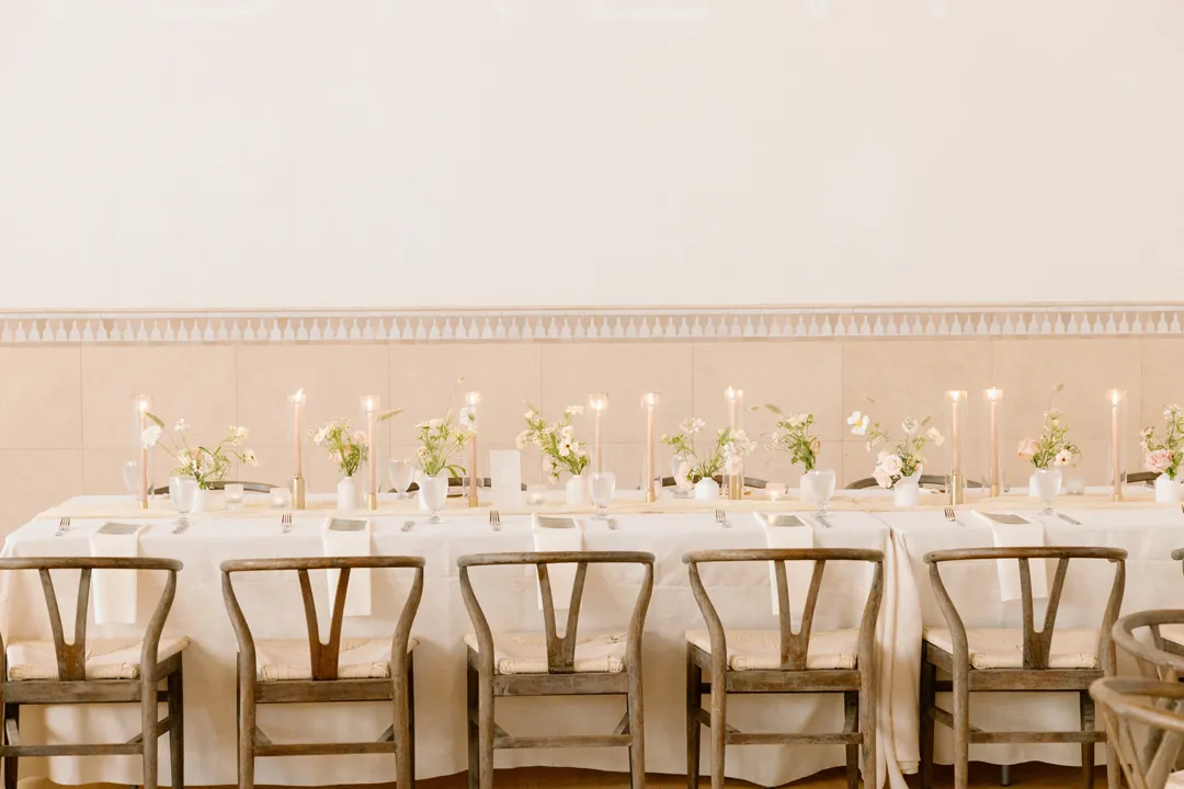 Long reception table set with pale flowers and candles