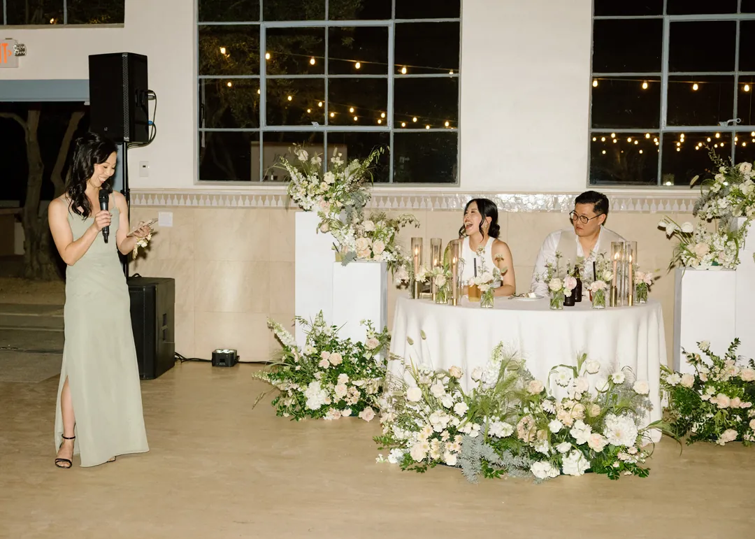 Guest giving a speech beside the seated couple