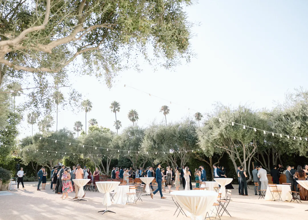 Guests mingling around outdoor cocktail tables