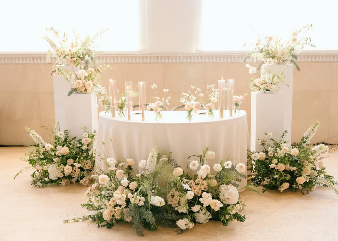 Sweetheart table surrounded by white and green flowers