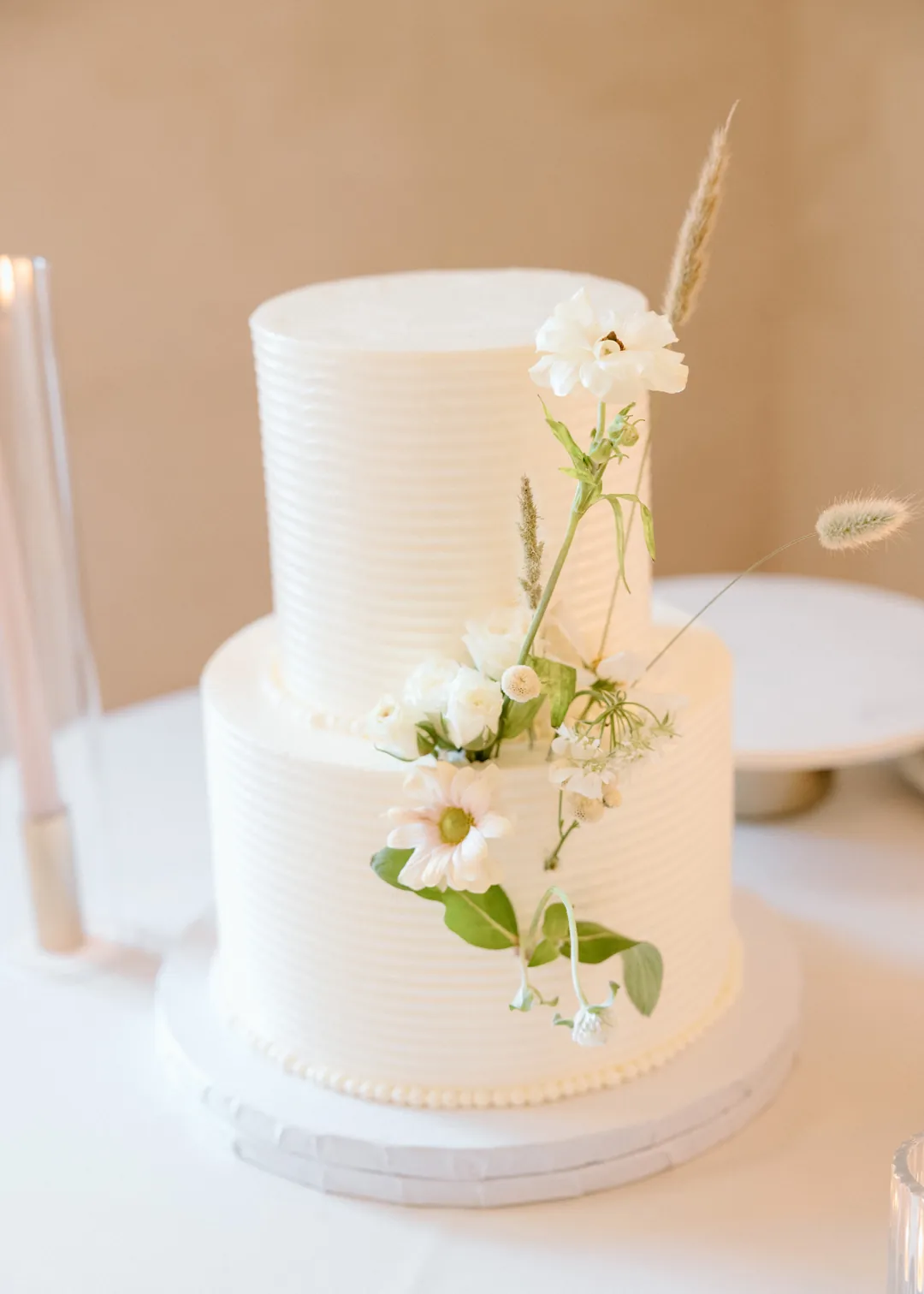 White tiered wedding cake with small green accents