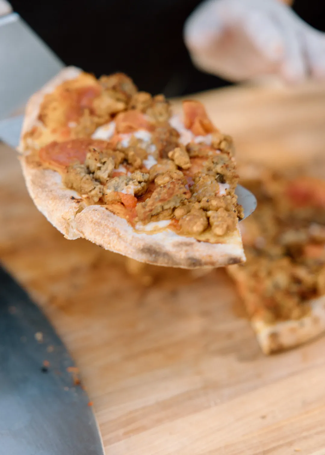 Chef holding a freshly prepared topped flatbread