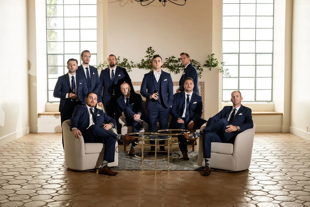 Groom and groomsmen posing around a lounge table