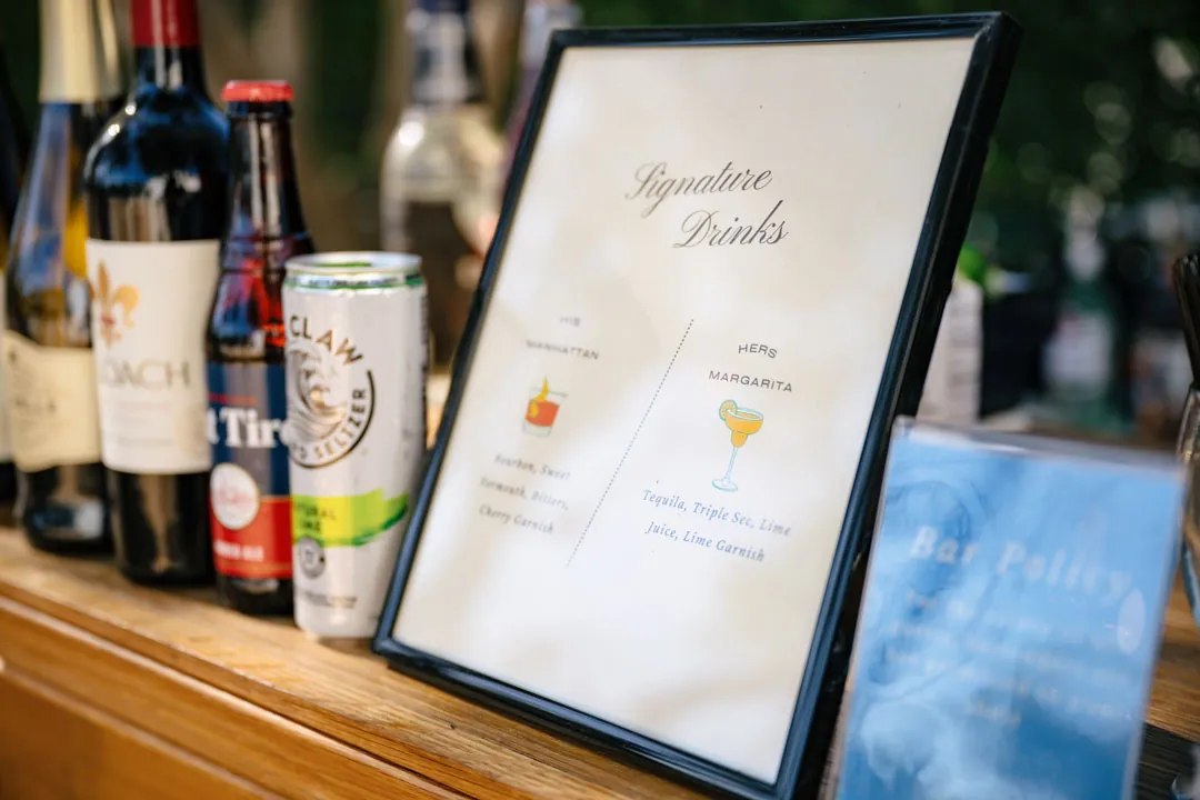 Bottles beside a framed signature drink menu