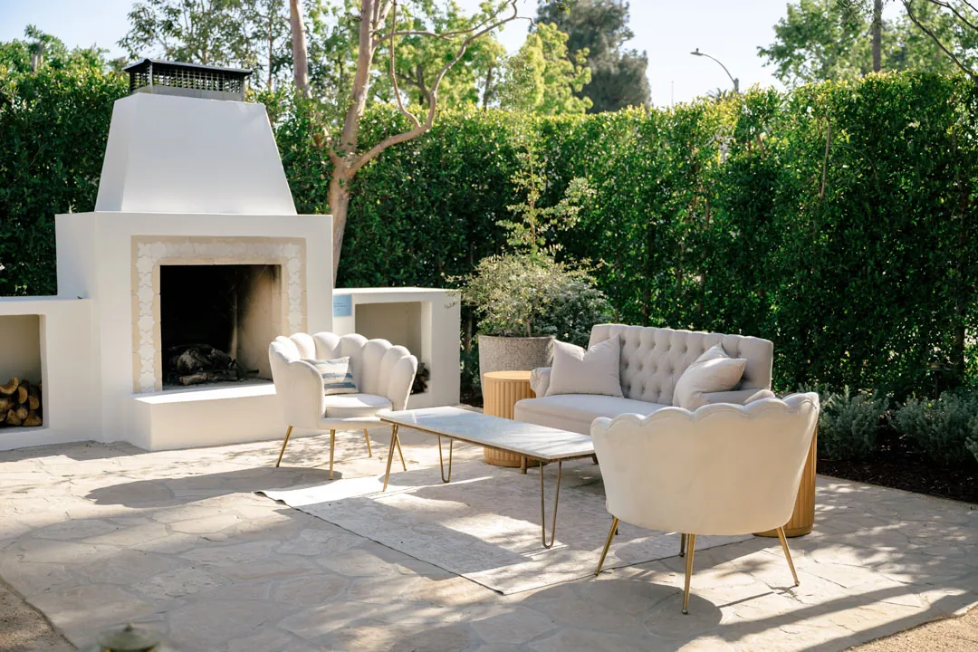 Outdoor lounge furniture beside the white fireplace