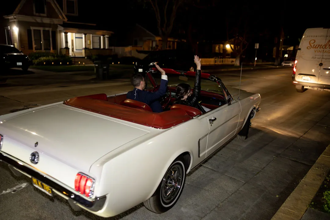 Bride and groom leaving in a white convertible
