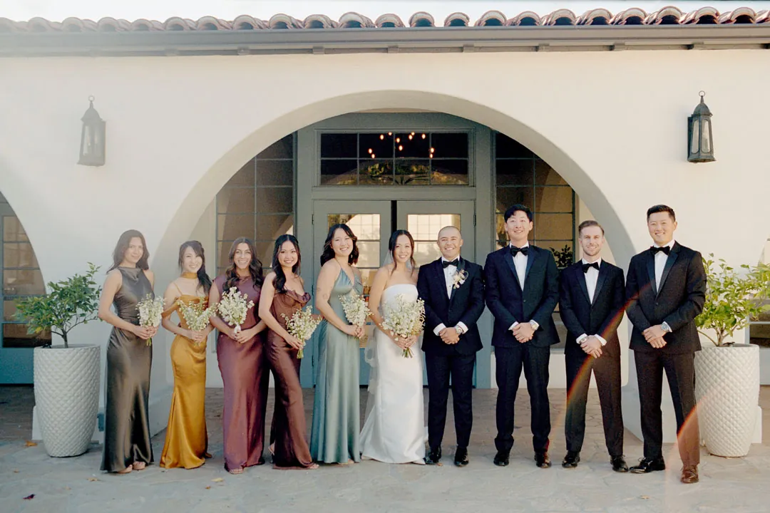 Wedding party posing beneath the venue's exterior archway