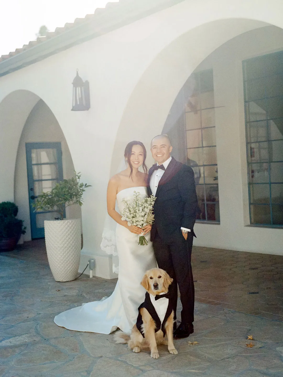 Bride and groom posing together with a dog