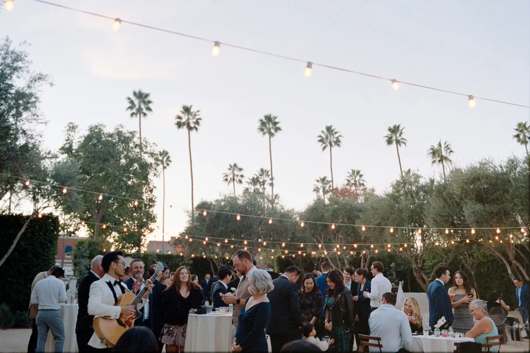 Guests socializing at outdoor cocktail tables near sunset