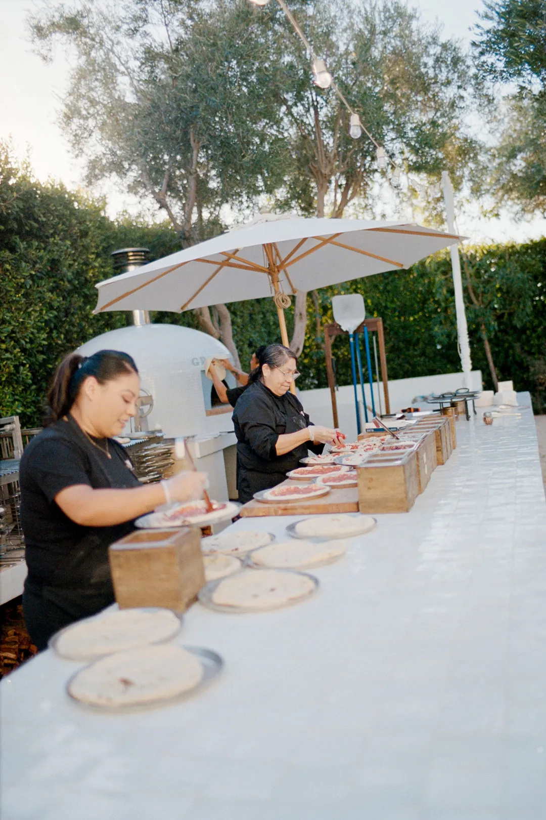 Catering team preparing pizzas at the courtyard counter