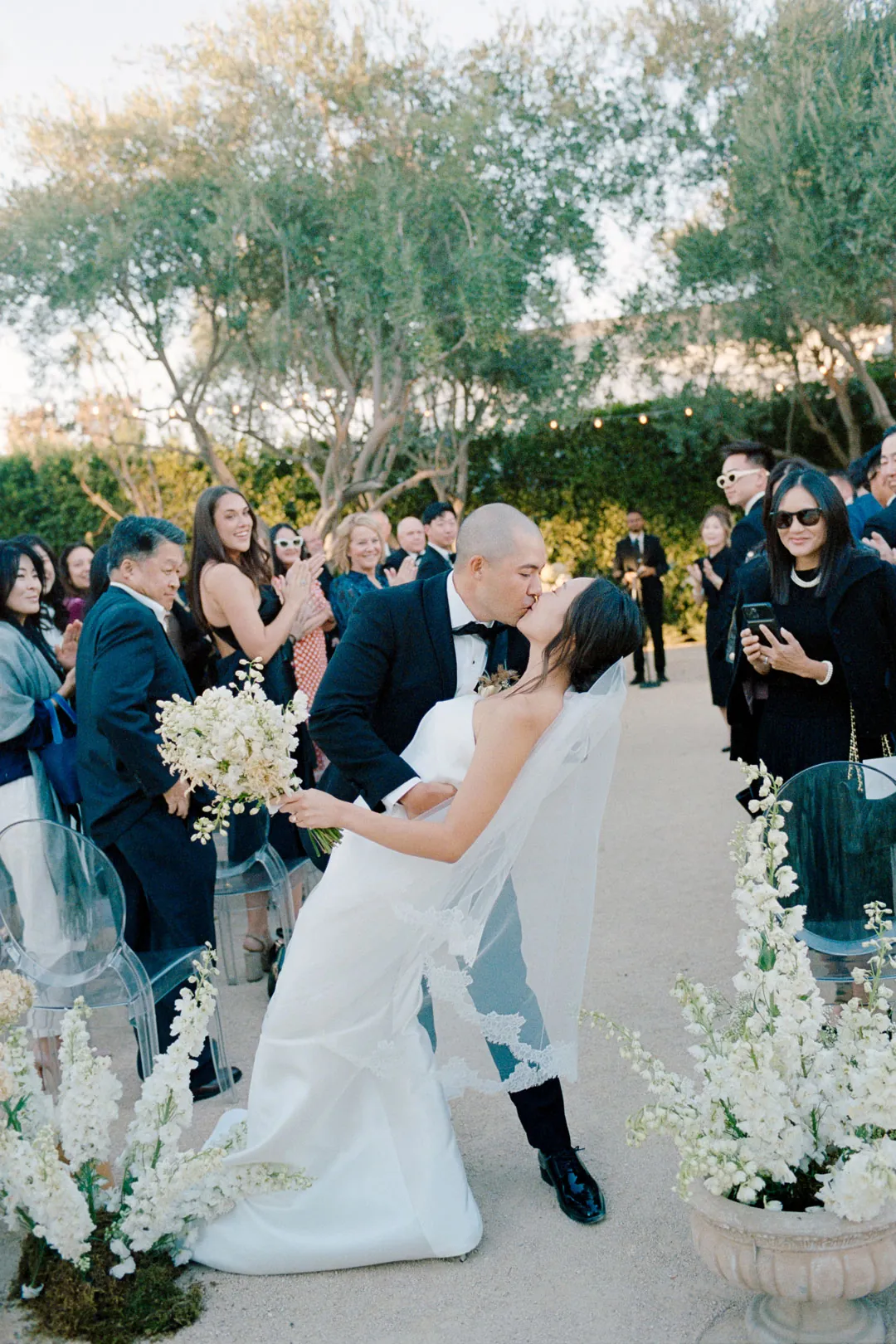 Groom dipping the bride in the wedding ceremony aisle