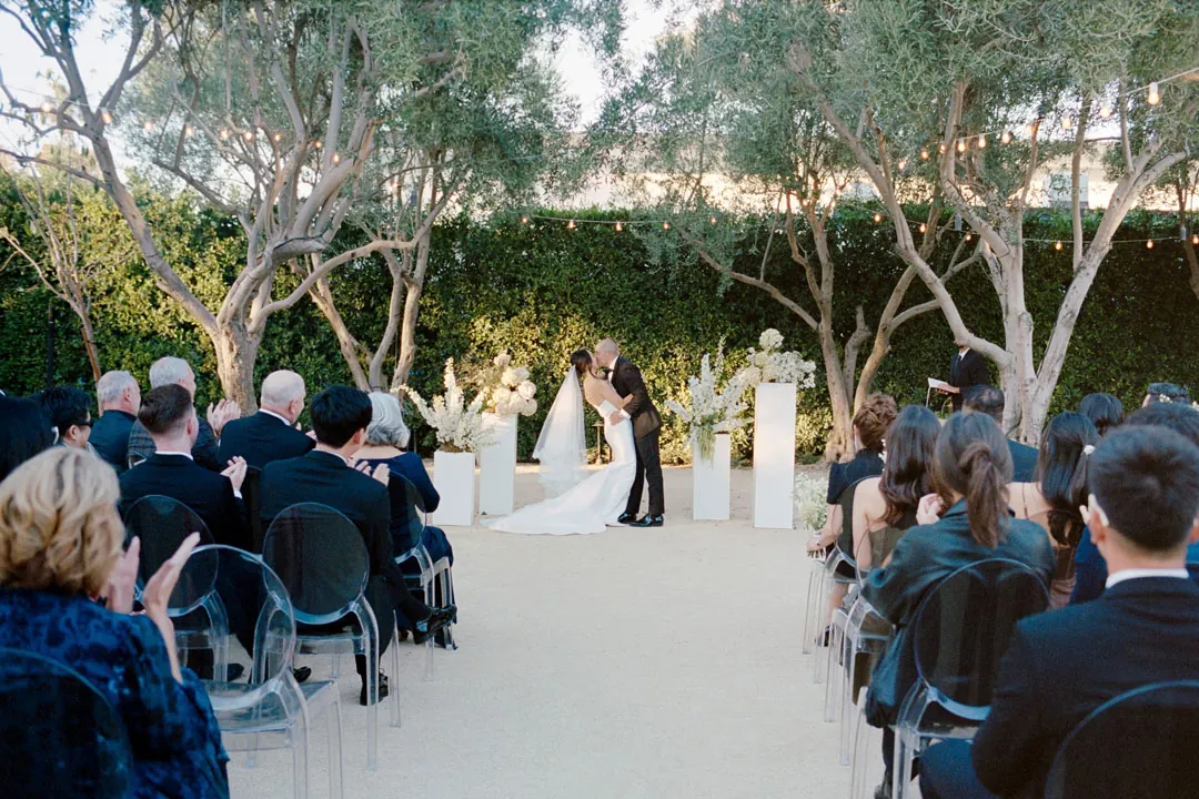 Guests watching the ceremony across the courtyard aisle