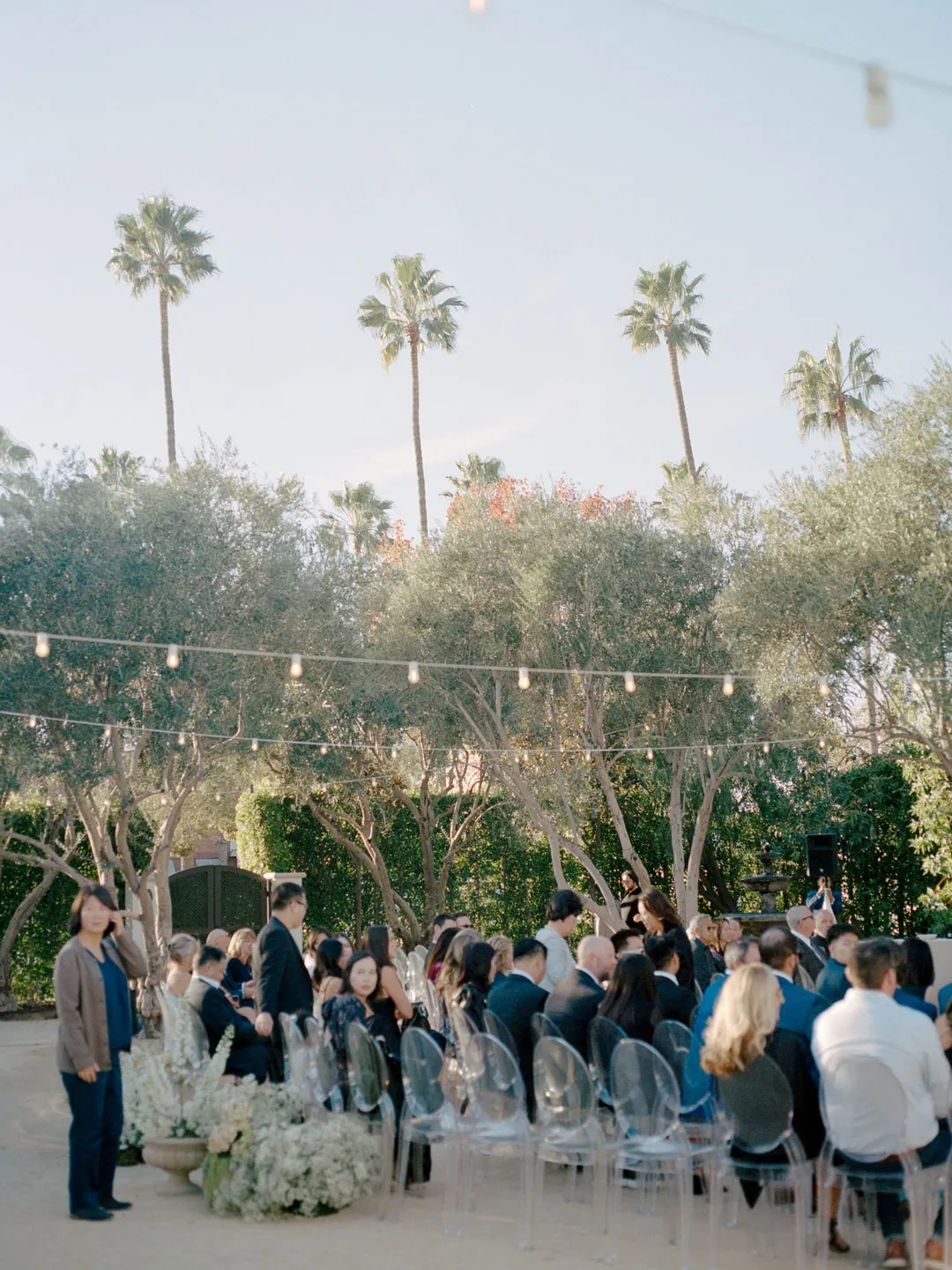 Guests standing for the outdoor wedding ceremony
