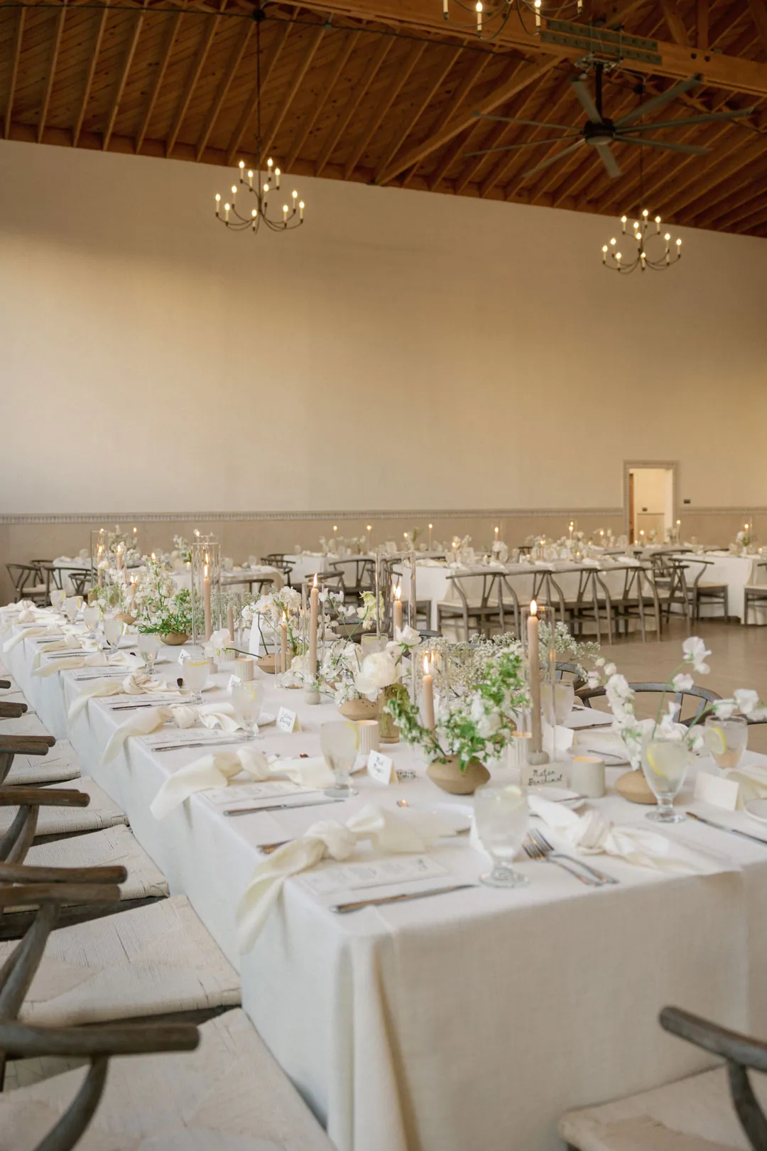 Long reception tables with white linens and floral centerpieces