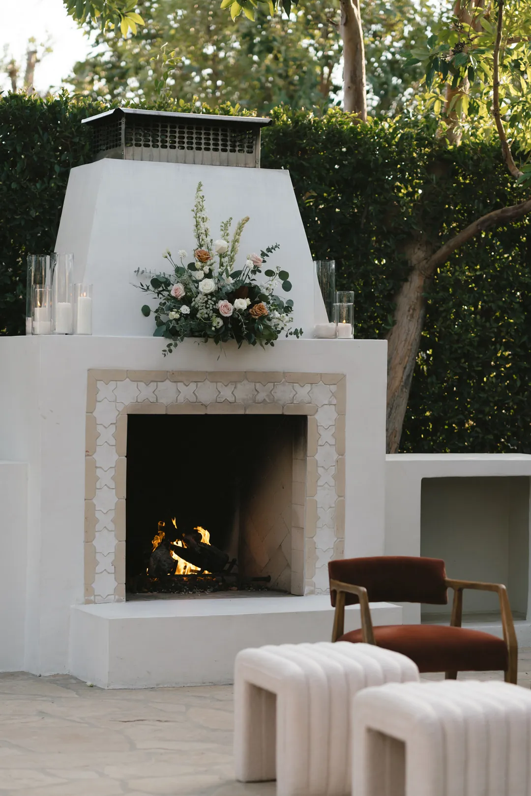 Outdoor fireplace with a floral arrangement above the mantel.