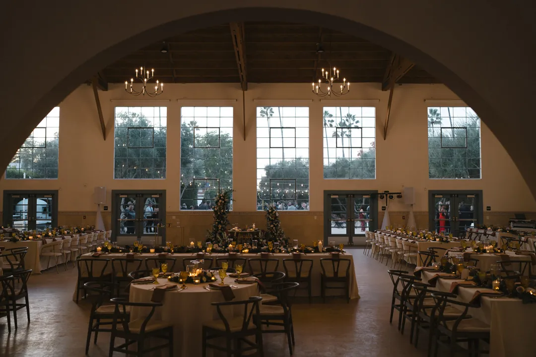 Reception dinner tables framed by an arched opening.