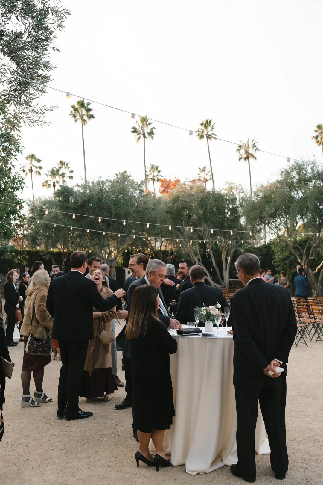Guests mingling around cocktail tables in the Olive Grove.