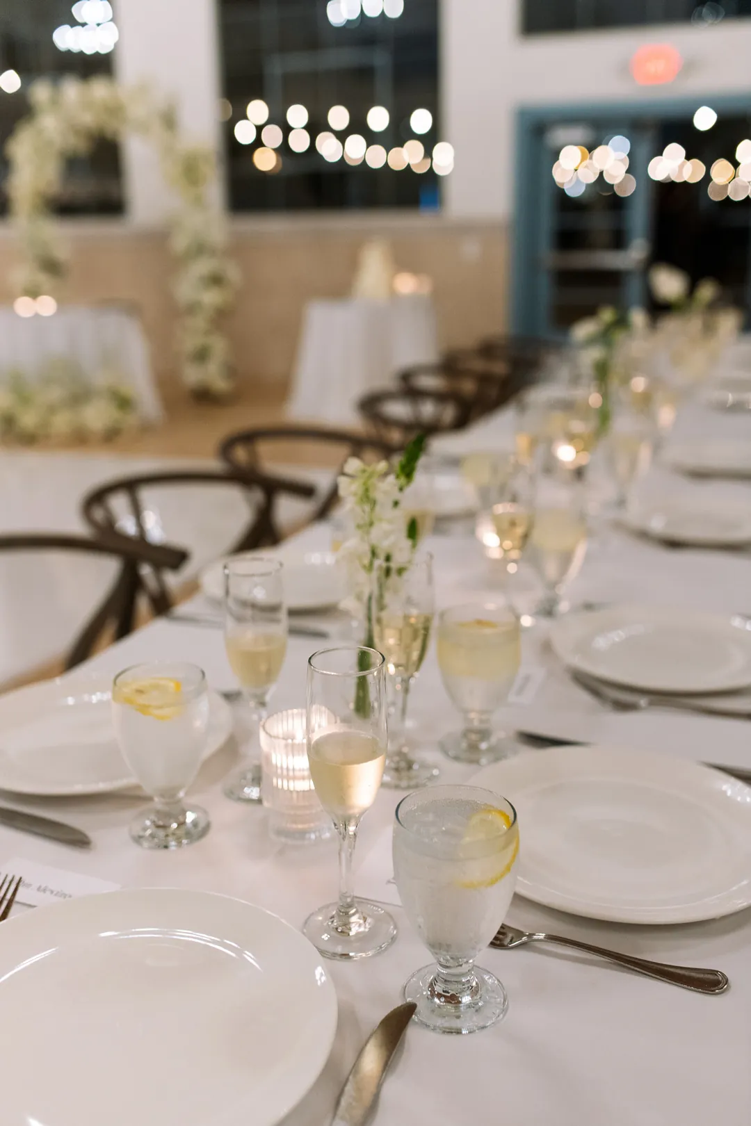 Candles and white flowers along a reception table