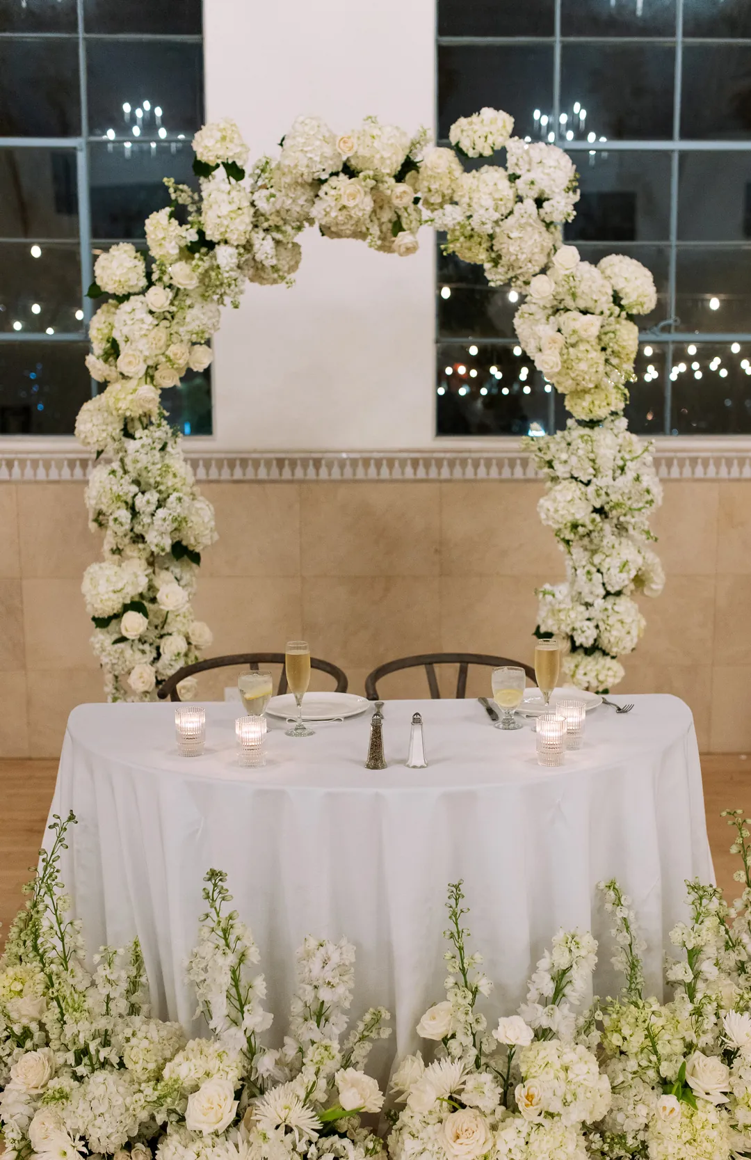 Sweetheart table surrounded by white flowers