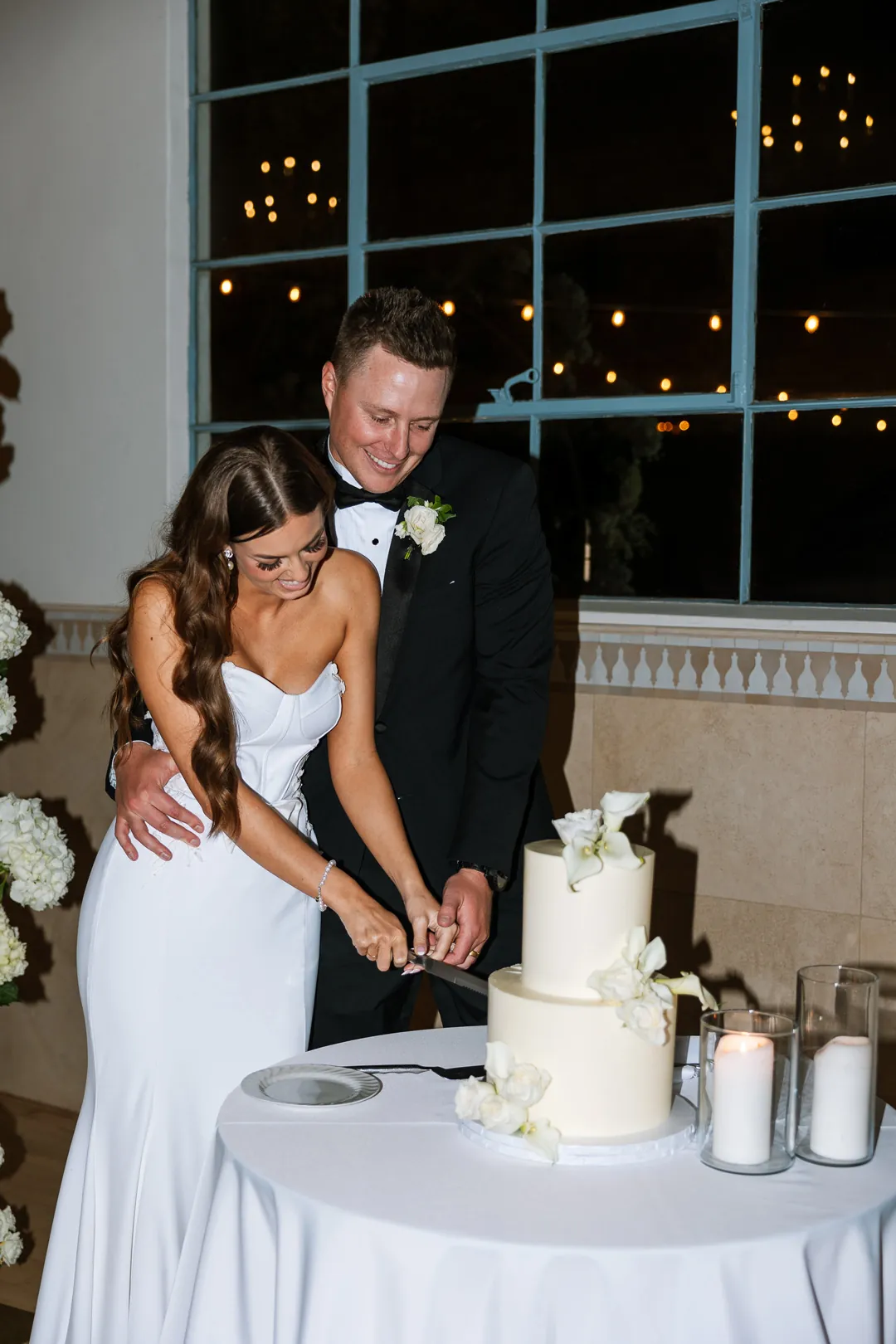 Bride and groom cutting their white wedding cake