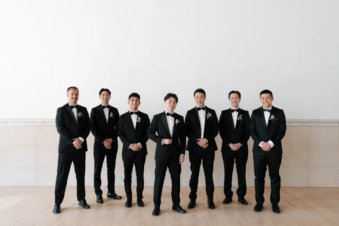 Groom and groomsmen posing in matching dark suits