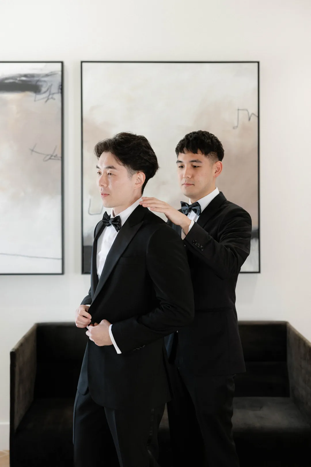 Groomsman helping the groom adjust his collar