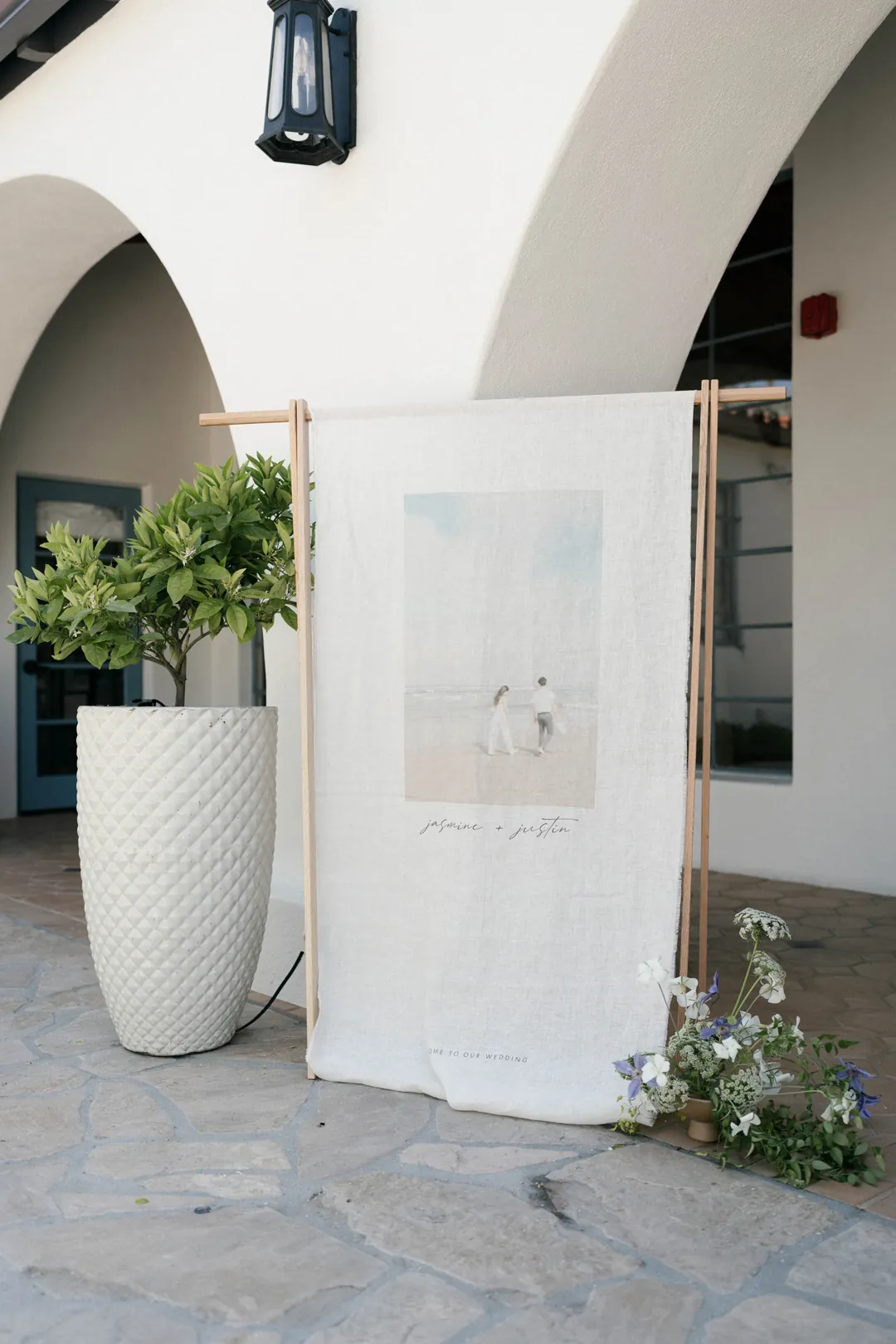 Printed wedding welcome sign beneath the courtyard arch