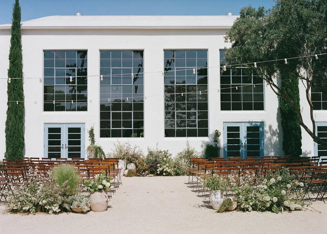 Outdoor ceremony aisle facing the venue's white reception hall
